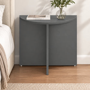 Modern charcoal half moon end table styled beside a bed