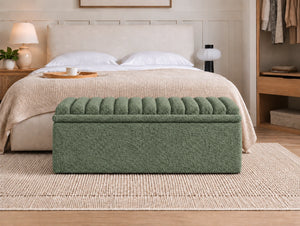 Green channel tufted upholstered ottoman at the foot of a bed