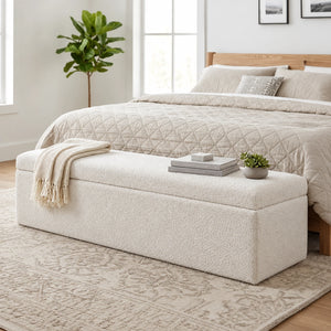 White upholstered storage ottoman bench at the foot of a bed