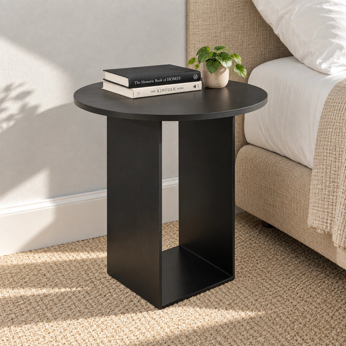 Black round end table beside bed