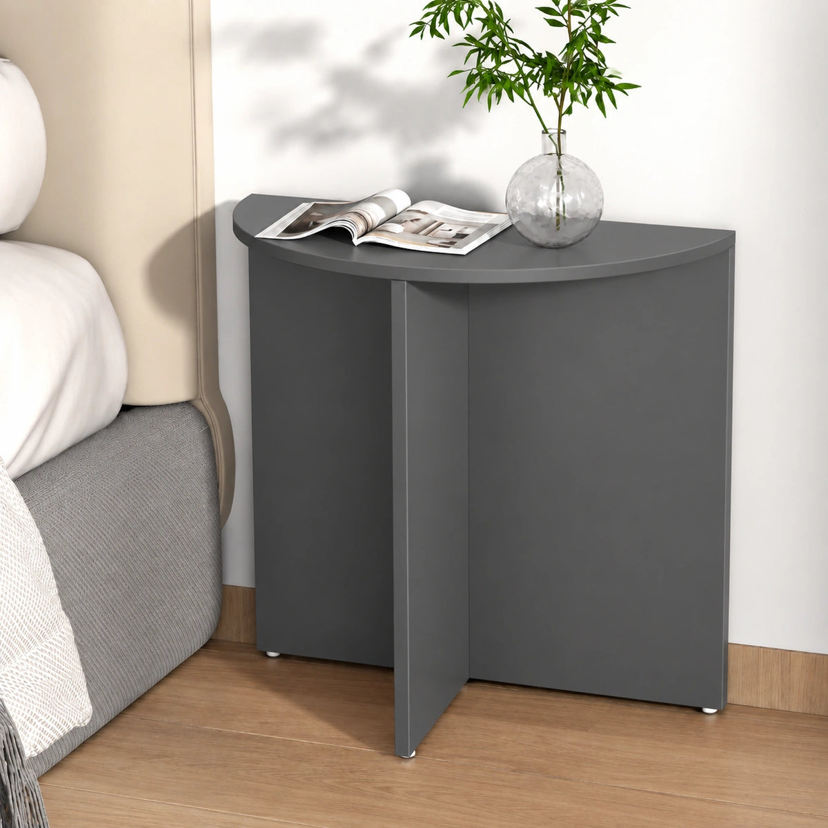 Charcoal half moon end table beside bed