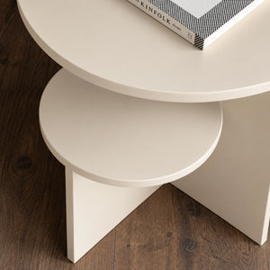 Close-up view of cream round side table with tiered shelves