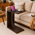 Dark brown C-shaped end table beside a sofa