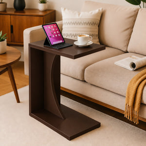 Dark brown C-shaped end table beside a sofa