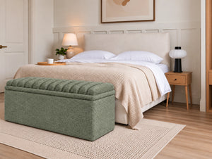 Green upholstered storage ottoman placed at the foot of a bed