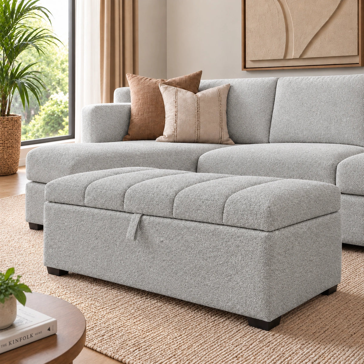 Light grey tufted storage ottoman in front of a sectional sofa