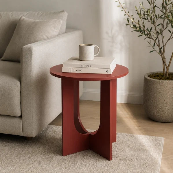 Maroon round end table beside sofa
