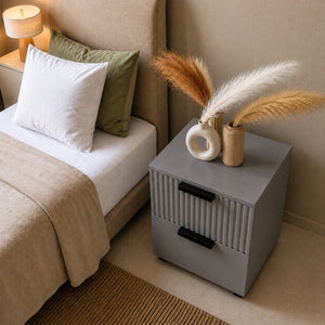 Top angle view of a Grey Solid Wood bedside table with decorative vases placed next to a modern upholstered bed.
